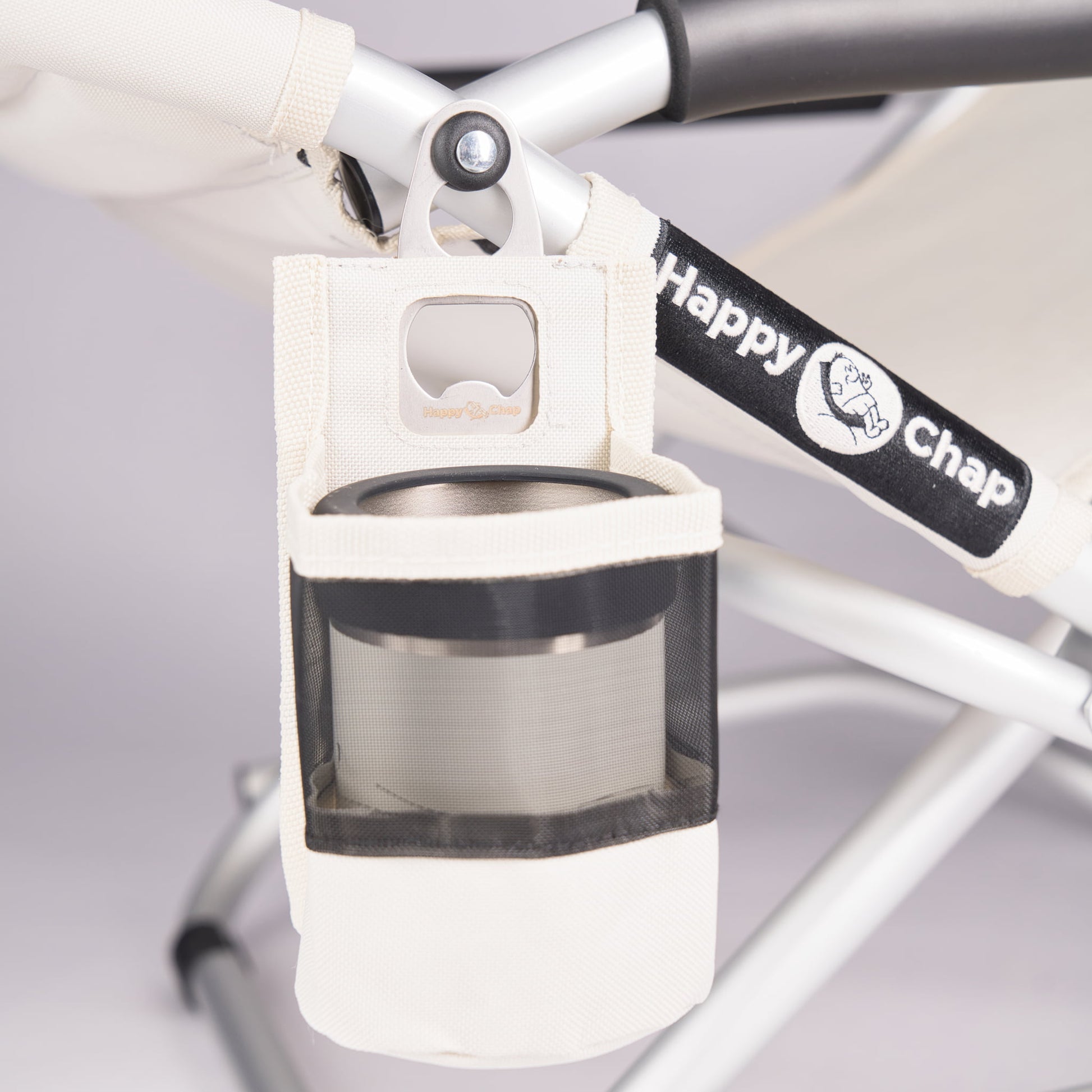 Detachable cup holder holding an insulated coffee cup attached to a happy chap outdoor chair 