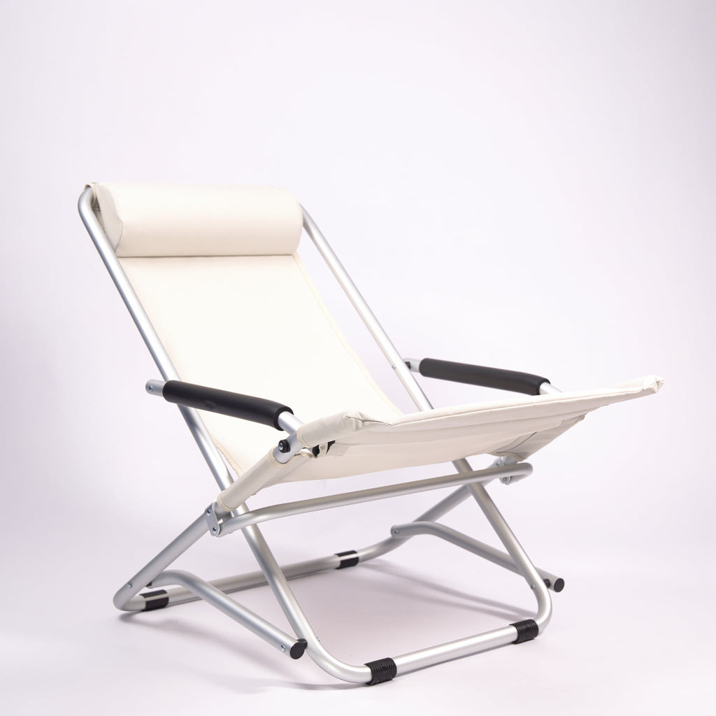 Foldable beach chair with sand-coloured seat , padded arm rests and backrest on a white background