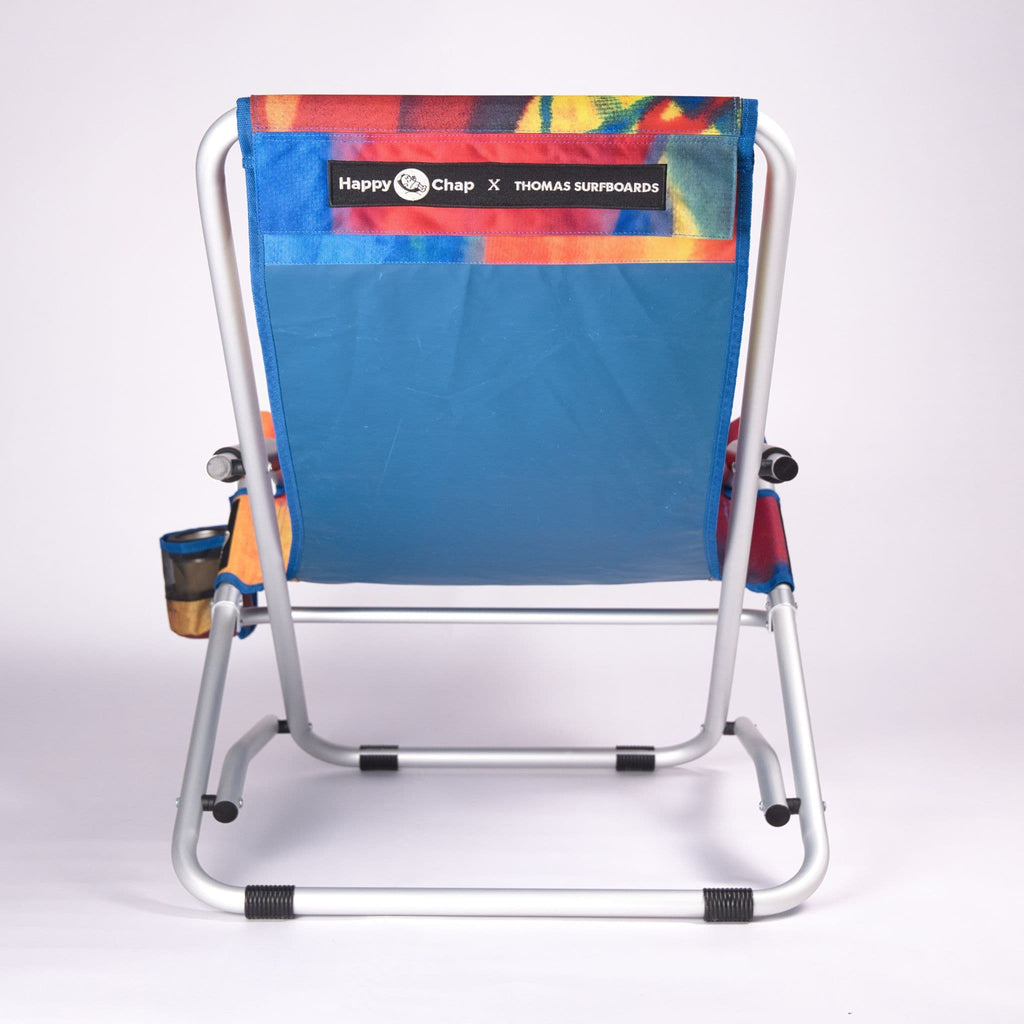 Colorful beach chair with 'Happy Chap' and 'Thomas Surfboards' branding on a white background